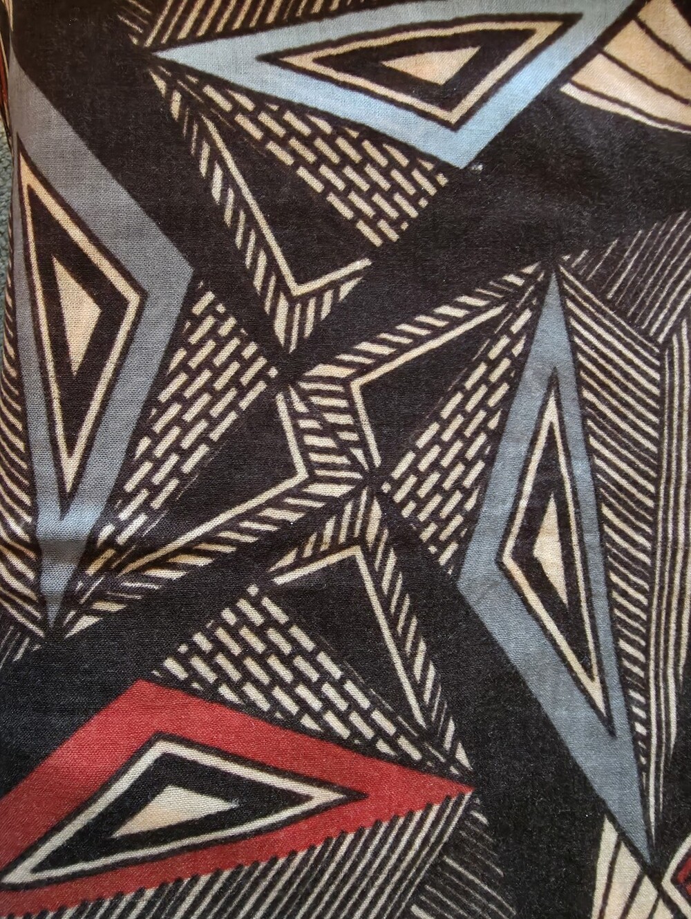 Large Geometric pattern in shades of blue, black, and red.